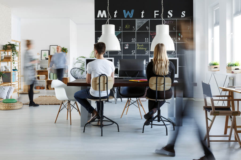 man and woman working at a desk in an office